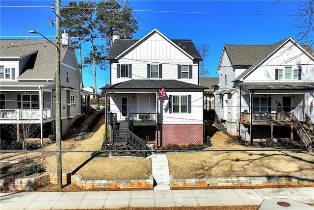 view of front of house with a shingled roof, a residential view, a porch, board and batten siding, and brick siding