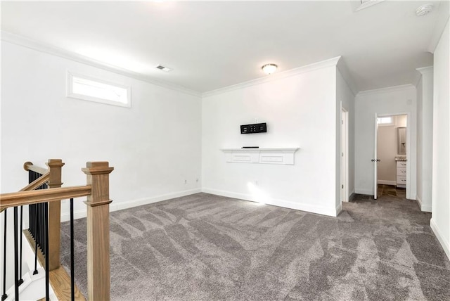 carpeted spare room featuring baseboards, visible vents, and crown molding