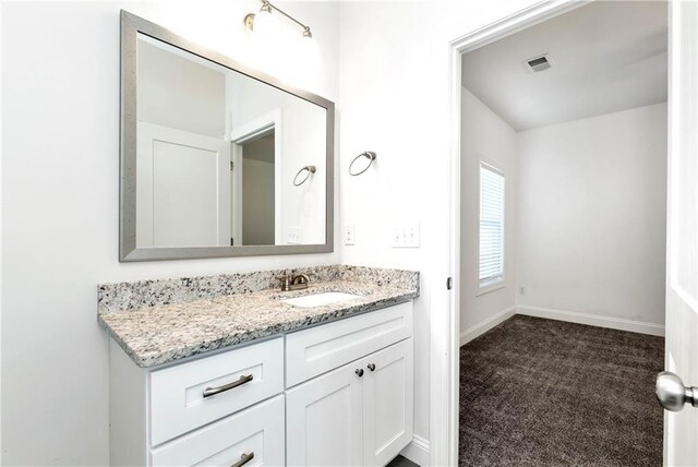 bathroom with vanity, visible vents, and baseboards