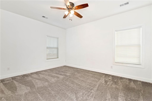 carpeted spare room featuring visible vents, ceiling fan, and baseboards