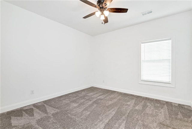 carpeted spare room with baseboards, visible vents, and ceiling fan