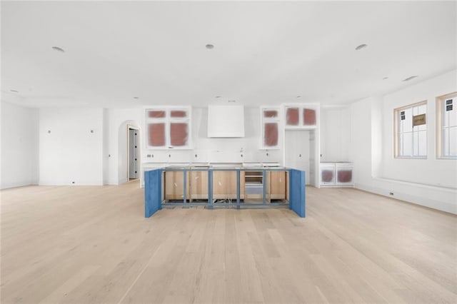 kitchen with light hardwood / wood-style floors, a kitchen breakfast bar, white cabinetry, and a kitchen island