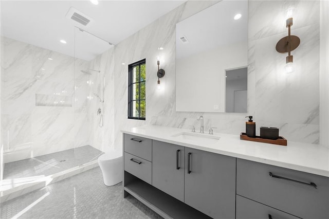 bathroom featuring tile walls, toilet, vanity, and a tile shower