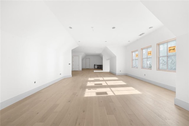 additional living space featuring light hardwood / wood-style flooring and vaulted ceiling