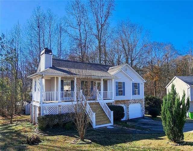 view of front of property with a porch, a garage, and a front lawn