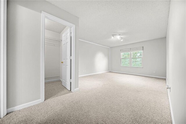 23 Chelsea Ct, Avondale Estates, GA 30002 - unfurnished bedroom featuring carpet, a walk in closet, a closet, baseboards, and a textured ceiling