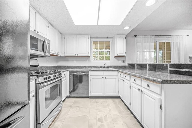 23 Chelsea Ct, Avondale Estates, GA 30002 - kitchen featuring a peninsula, a sink, white cabinetry, and black appliances