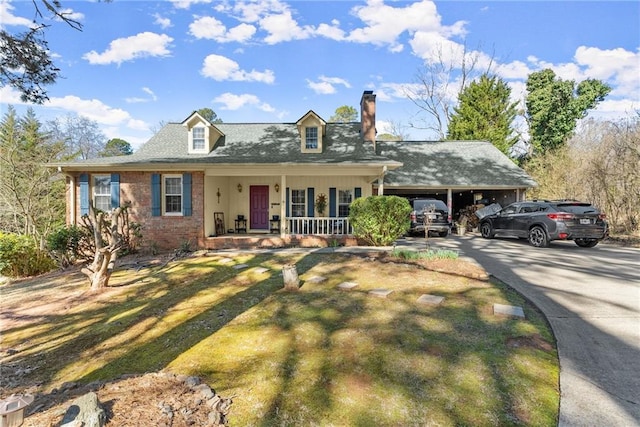 view of front of property with brick siding, a chimney, a porch, a carport, and driveway