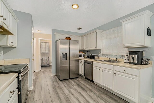 kitchen featuring white cabinets, light wood-type flooring, stainless steel appliances, and sink