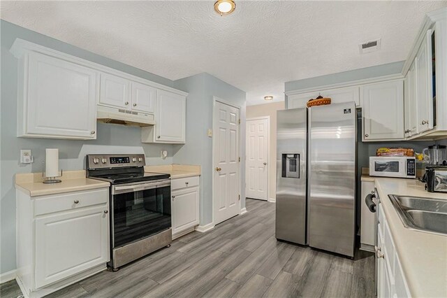 kitchen with white cabinets and appliances with stainless steel finishes