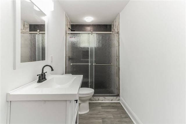 bathroom featuring hardwood / wood-style floors, vanity, toilet, and an enclosed shower