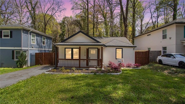 view of front of property featuring covered porch and a lawn