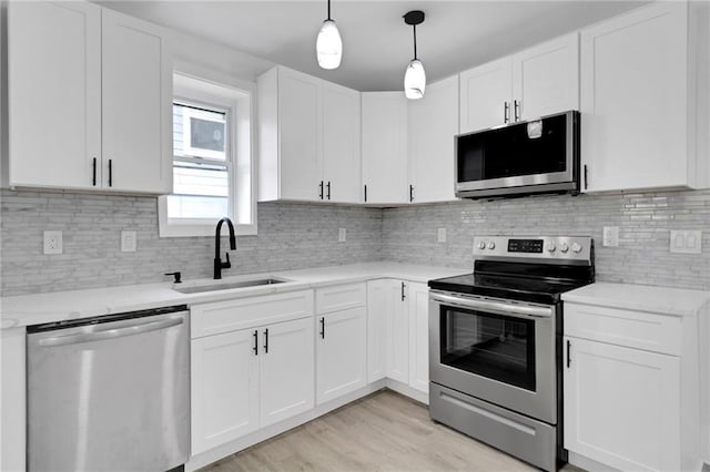 kitchen featuring sink, white cabinets, light wood-type flooring, and appliances with stainless steel finishes