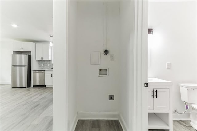 clothes washing area featuring washer hookup, electric dryer hookup, and light hardwood / wood-style flooring