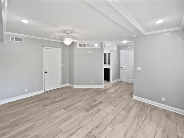 spare room with crown molding, visible vents, a ceiling fan, and baseboards