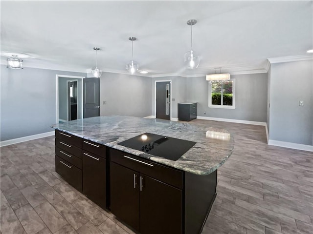 kitchen with black electric stovetop, baseboards, open floor plan, and crown molding