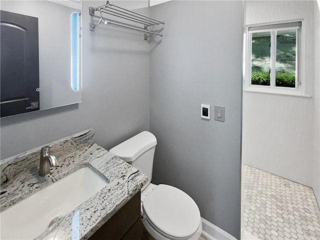 full bath with walk in shower, vanity, toilet, and baseboards