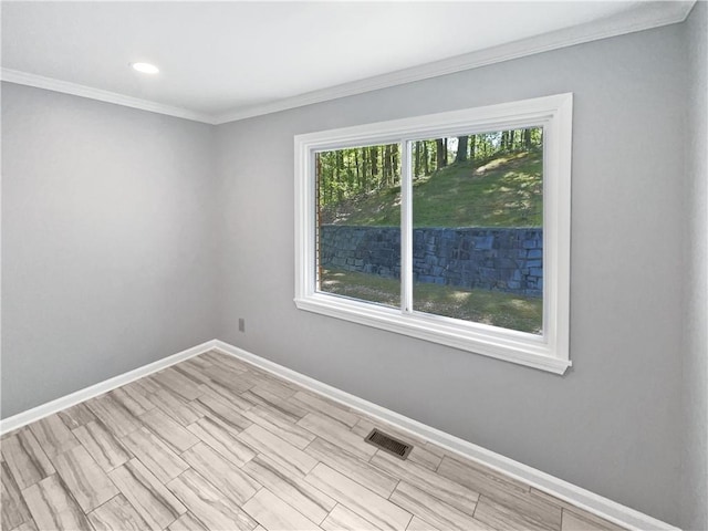 spare room featuring baseboards, ornamental molding, visible vents, and recessed lighting