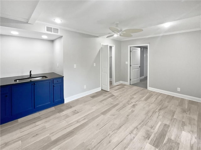 interior space with light wood-type flooring, visible vents, ceiling fan, and a sink