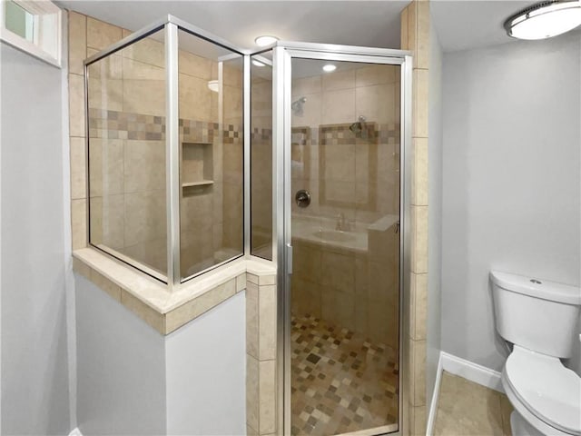 full bath featuring a stall shower, baseboards, and toilet
