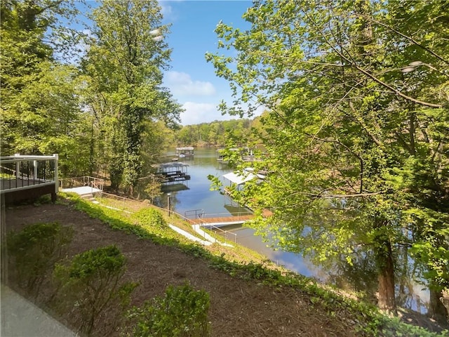 view of water feature with a view of trees and a dock