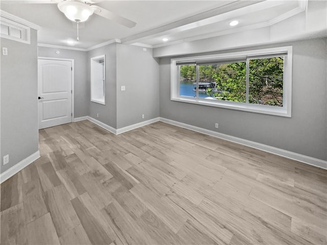 unfurnished room featuring light wood finished floors, baseboards, ceiling fan, and crown molding