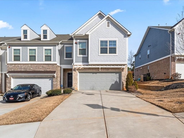 view of front facade featuring driveway, brick siding, and an attached garage