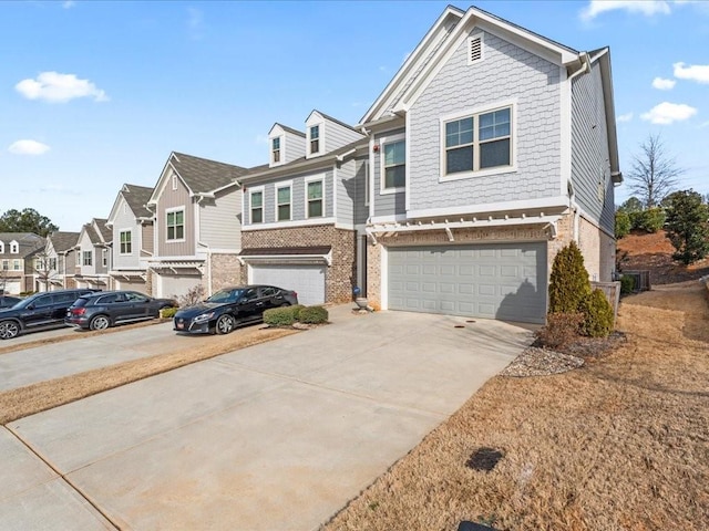 view of front of home featuring driveway, brick siding, an attached garage, and a residential view