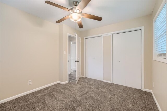 unfurnished bedroom with two closets, ceiling fan, and carpet floors