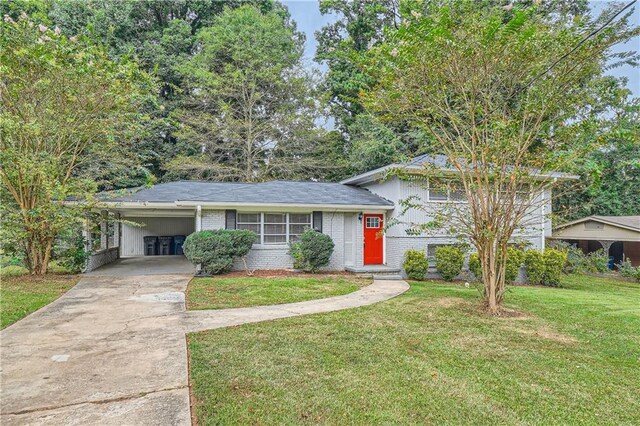 tri-level home featuring a front lawn and a carport