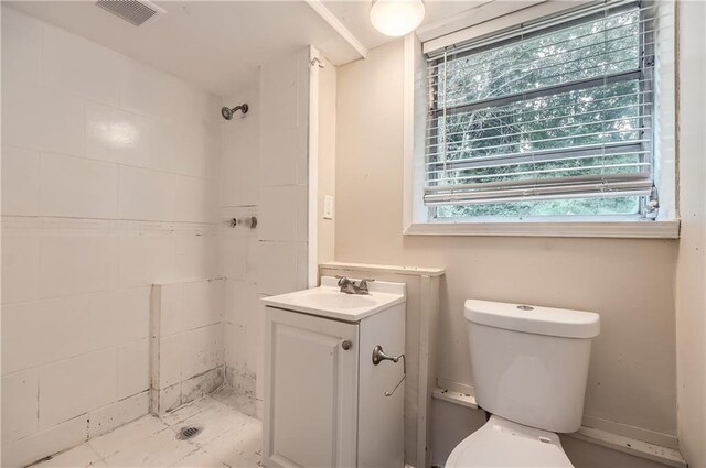 bathroom featuring vanity, a shower, and toilet