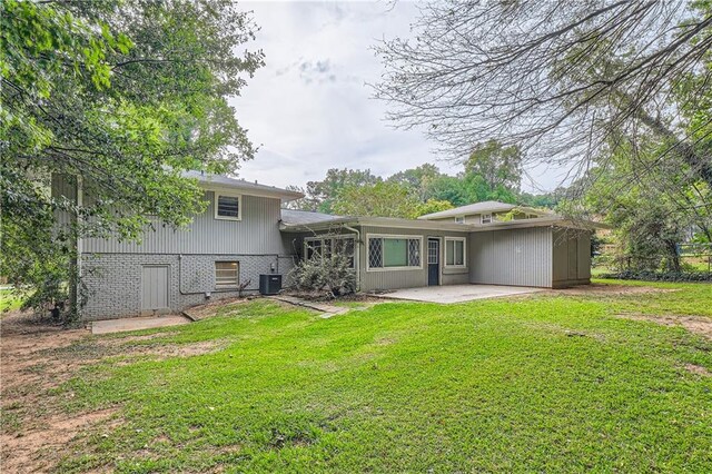 back of property with central AC unit, a yard, and a patio