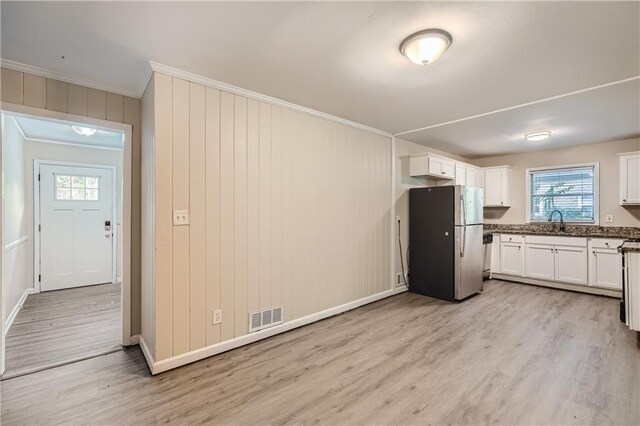 kitchen featuring white cabinets, stainless steel fridge, and light hardwood / wood-style floors