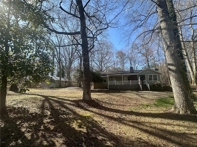 view of front of house featuring covered porch and a chimney