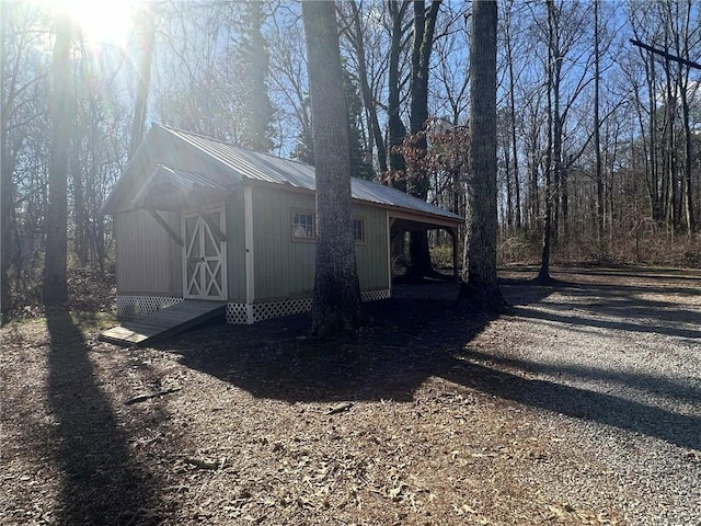 view of side of property featuring metal roof and an outdoor structure