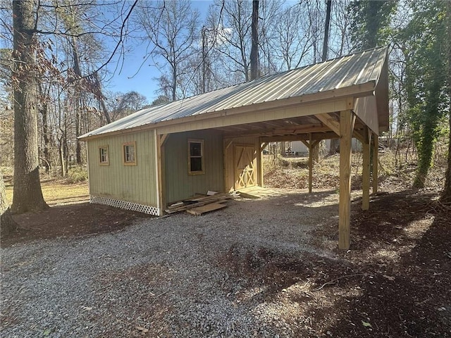 view of outdoor structure featuring gravel driveway and an outbuilding