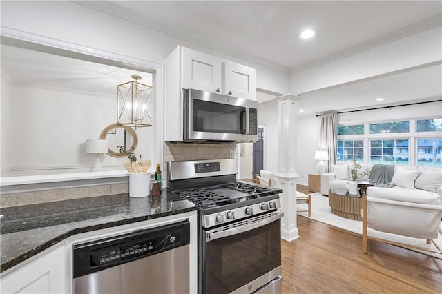 2070 Drew Valley Rd NE, Brookhaven, GA 30319 - kitchen with appliances with stainless steel finishes, ornate columns, ornamental molding, white cabinets, and dark stone counters