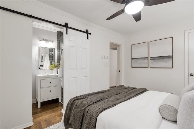 2070 Drew Valley Rd NE, Brookhaven, GA 30319 - bedroom featuring a barn door, wood finished floors, crown molding, ceiling fan, and ensuite bath