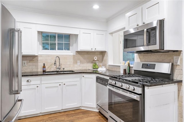 2070 Drew Valley Rd NE, Brookhaven, GA 30319 - kitchen with stainless steel appliances, dark stone counters, white cabinets, decorative backsplash, and ornamental molding