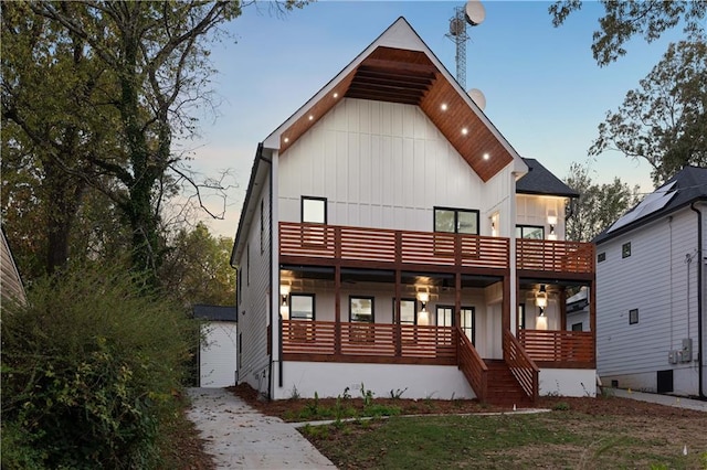 back house at dusk with a porch and a balcony