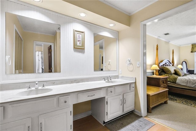 bathroom with double vanity, ornamental molding, ensuite bath, and a sink