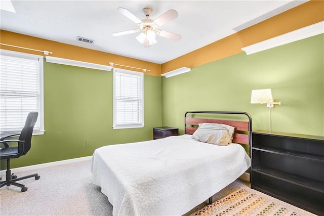 carpeted bedroom with ceiling fan and baseboards