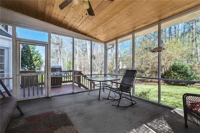 sunroom with wooden ceiling, plenty of natural light, a ceiling fan, and lofted ceiling