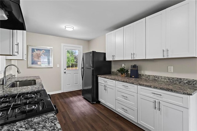 629 Dunton Cir SE, Smyrna, GA 30082 - kitchen featuring a sink, freestanding refrigerator, dark wood-style flooring, ventilation hood, and dark stone counters