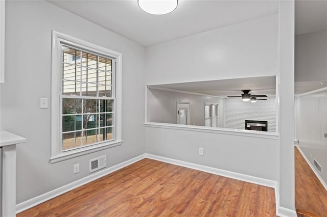 2002 Twin Falls Rd, Decatur, GA 30032 - spare room with wood finished floors, a ceiling fan, and a fireplace