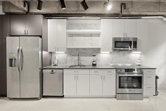 kitchen featuring stainless steel appliances, tasteful backsplash, sink, and white cabinets