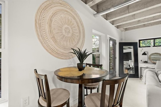 dining space featuring beamed ceiling