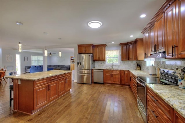 2944 Berry Rd, Loganville, GA 30052 - kitchen with brown cabinets, stainless steel appliances, light wood finished floors, and open floor plan