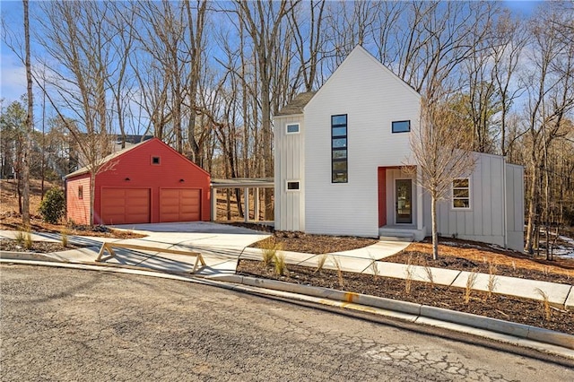 view of front of house with a garage, board and batten siding, and an outbuilding