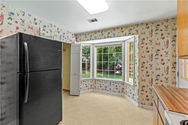 5340 Young Deer Dr, Cumming, GA 30041 - kitchen featuring freestanding refrigerator, wallpapered walls, baseboards, light flooring, and range
